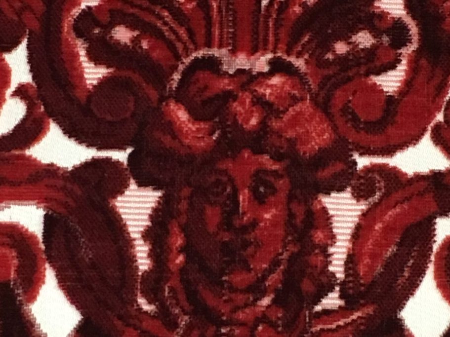 Ornamentdetail des restaurierten Polsterstoffs Nahaufnahme eines gewebten Maskenmotivs im barocken Damastbezug