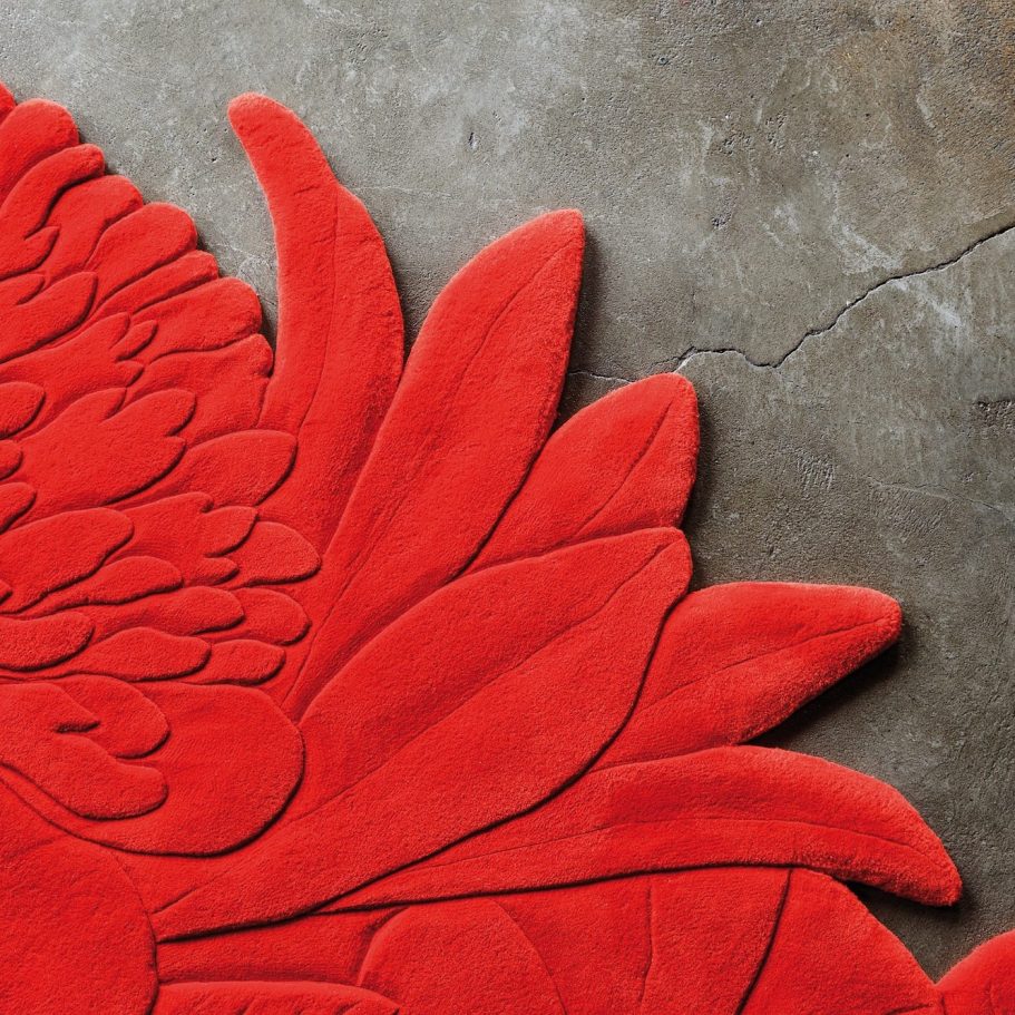 Individuelle Teppichgestaltung Rotes, plastisch gearbeiteter Teppich mit Blatt- und Federmotiv auf Betonboden