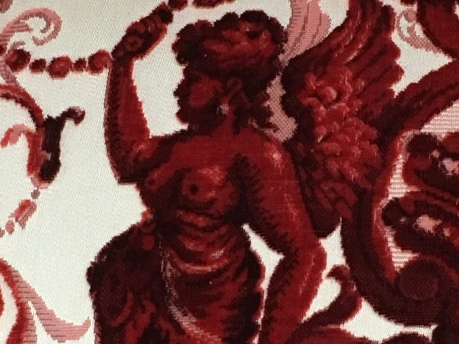 Figürliches Motiv im Polsterstoff Detailaufnahme einer geflügelten Putte im Damastmuster des Bezugsstoffs
