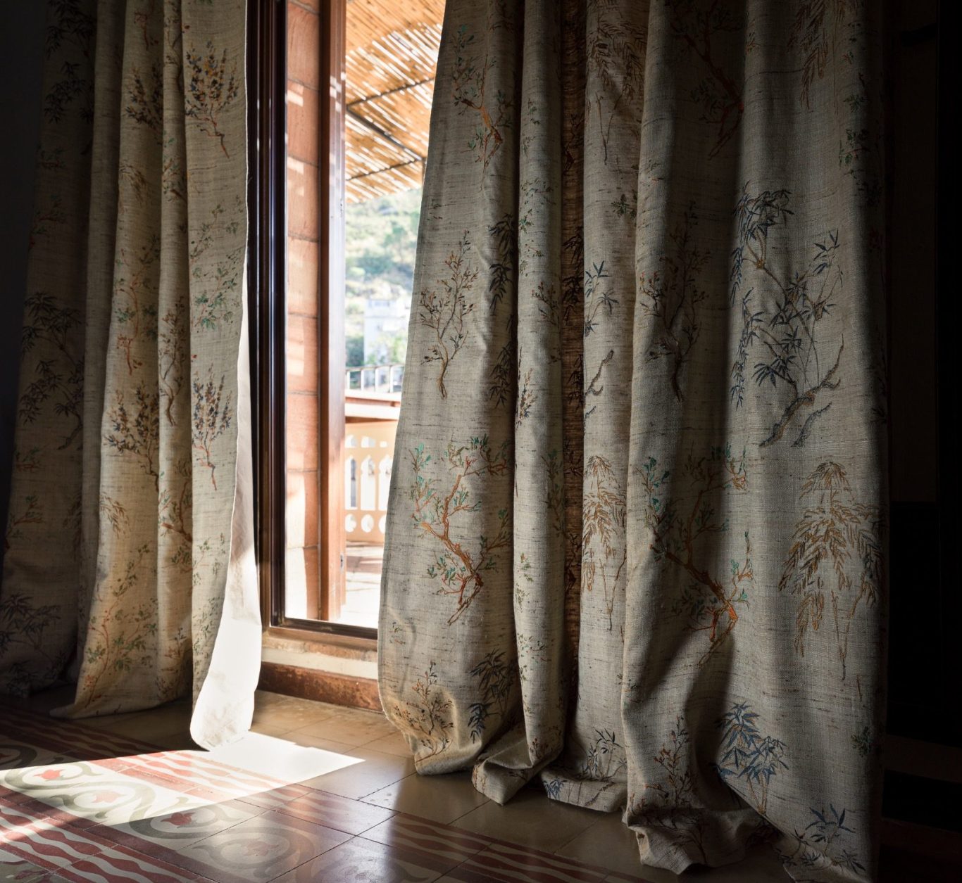 Fenstergestaltung mit exklusivem Vorhangstoff Bodenlanger Vorhang mit Kranich- und Bambusmuster vor einer Balkontür mit Bergblick