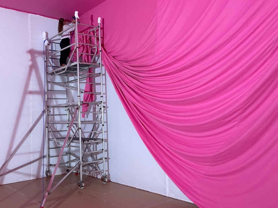Aufbau der Rauminstallation vor Ort Montage der pinkfarbenen Stoffbahnen an einem Gerüst im Museumsraum